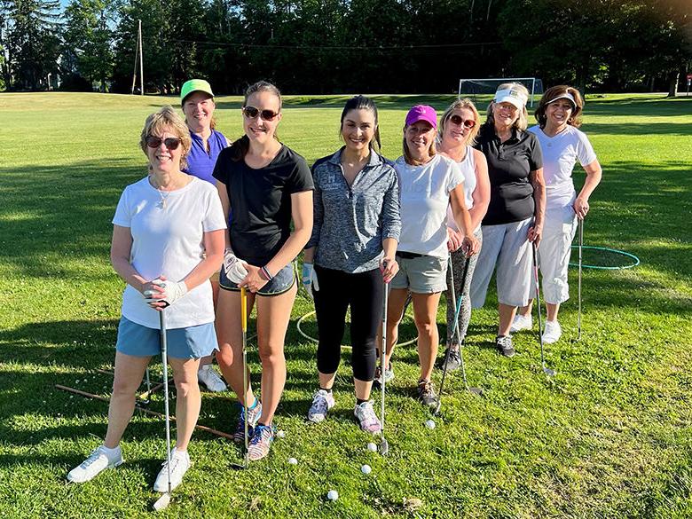 A group of women golfers posing with their clubs